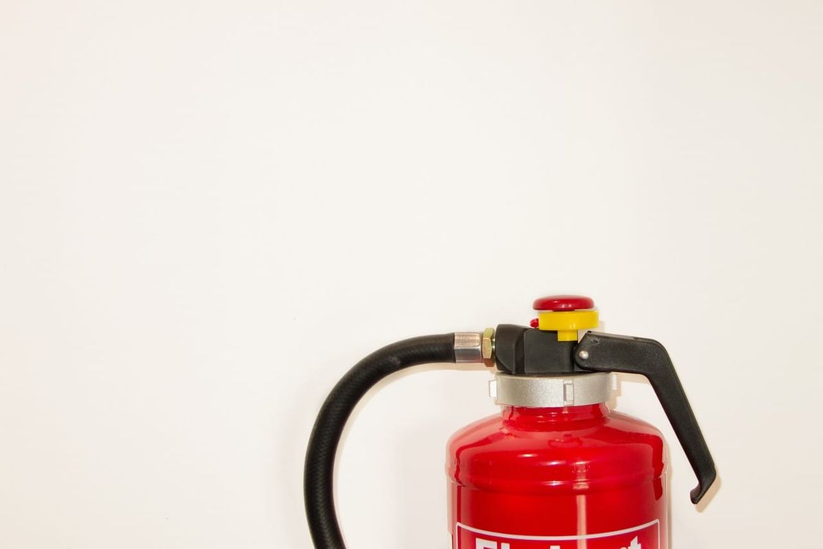 Symbolbild: Ein roter Feuerlöscher vor hellem Hintergrund