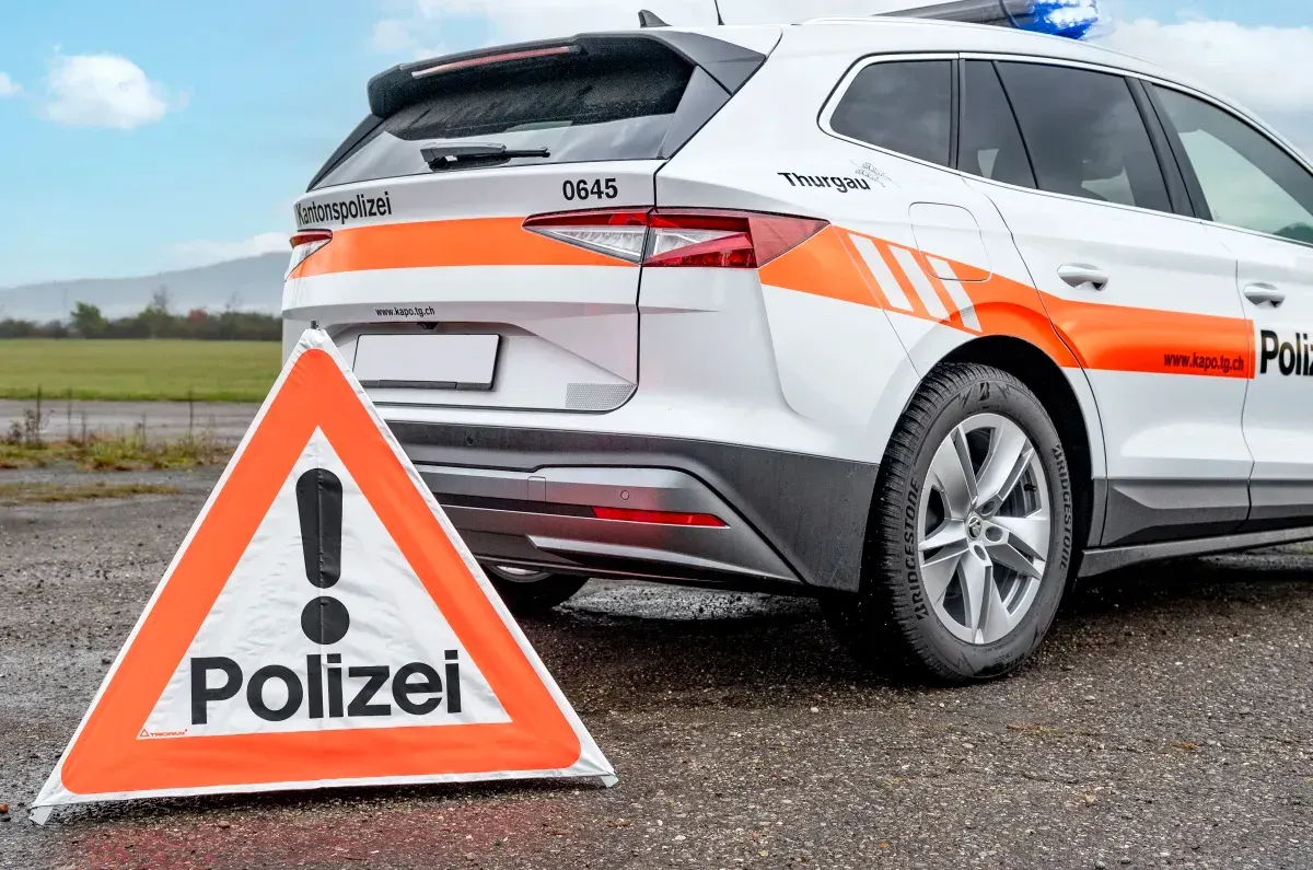 Im Bild sieht man ein Polizeifahrzeug der Kantonspolizei Thurgau neben einem aufgestellten Warnschild mit Aufschrift 'Polizei'. Der Himmel ist leicht bewölkt.