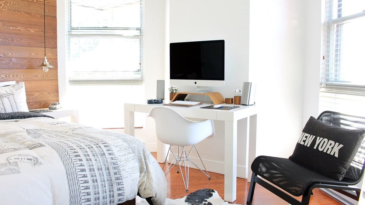 Helles Schlafzimmer mit Bett, Schreibtisch und Sessel