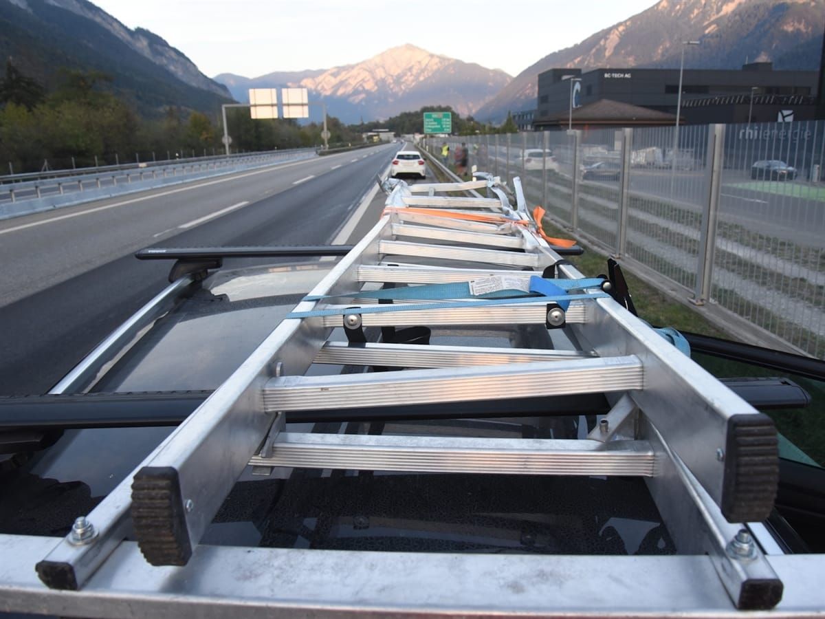 Die demolierte Leiter auf einem Autodach. Blick auf die Autobahn.