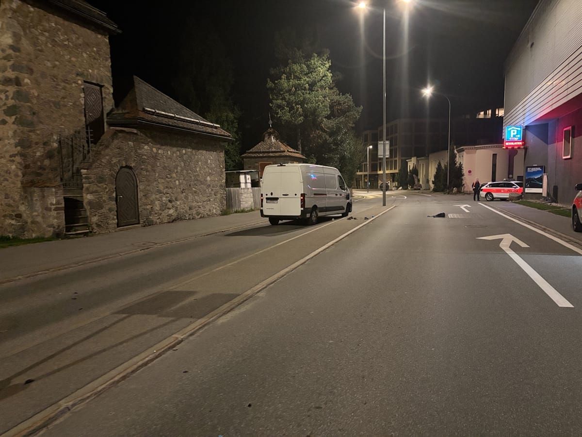 Links von einer Verkehrsinsel steht ein weisser Lieferwagen. Rechts der Strasse zwei Polizeiautos.