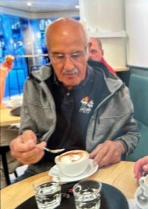 Ein älterer Mann mit Halbglatze, Schnauz und weissem Haarkranz am Kaffee Trinken