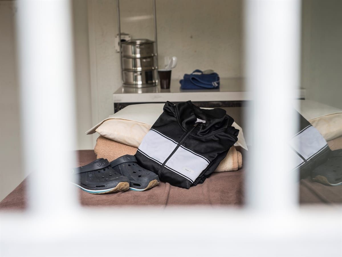 Blick durch Gitterstäbe in eine Zelle