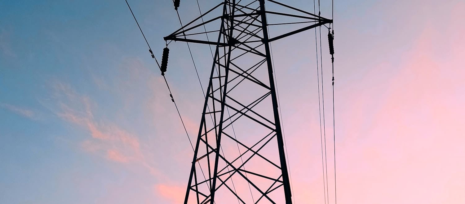 High-voltage transmission lines at dusk — power is the binding constraint