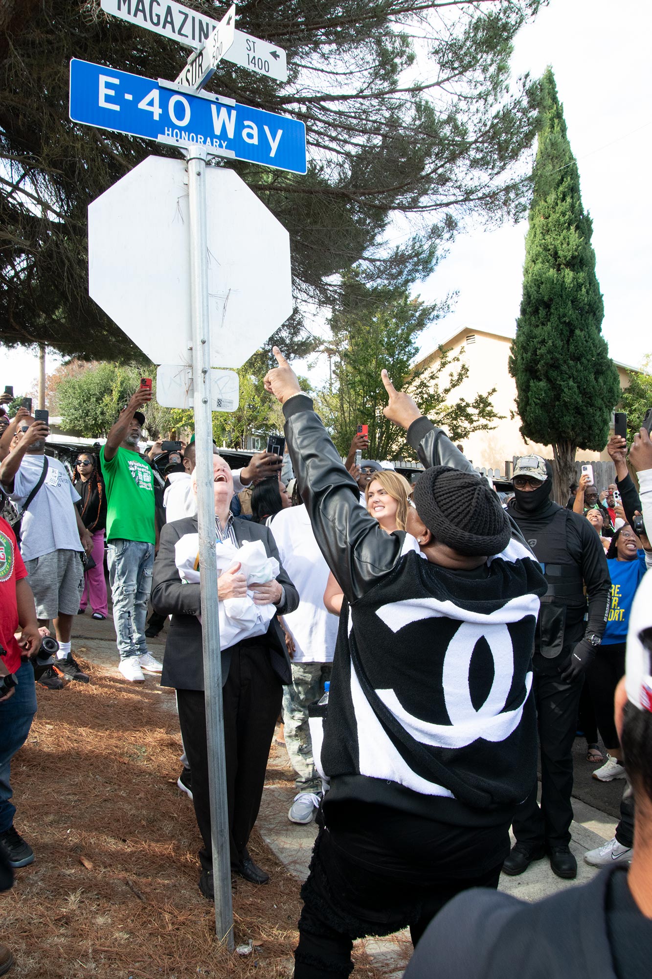 E-40 points at a sign designating his childhood street as E-40 Way
