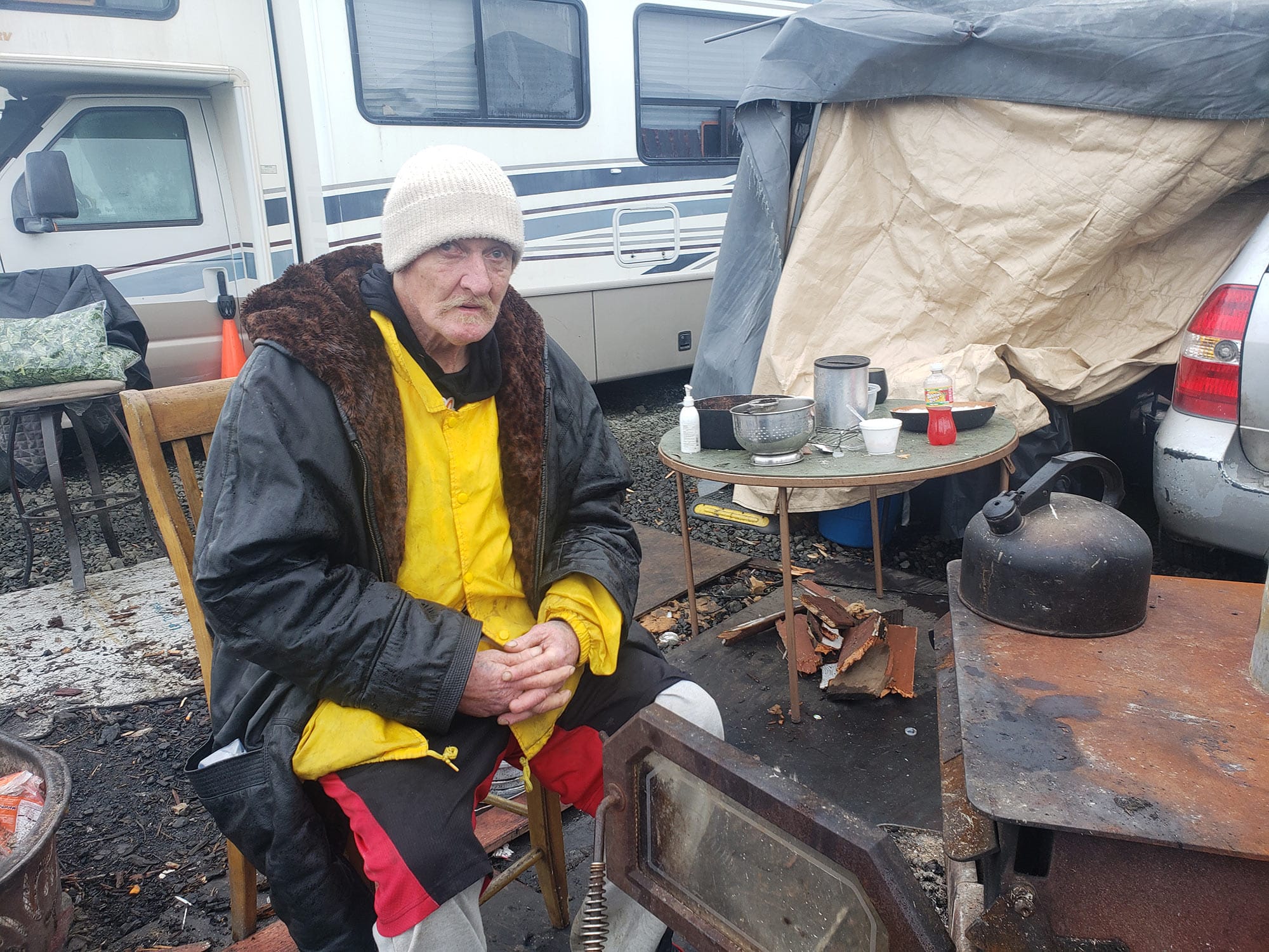 &nbsp;Mackie Kent warms up the stove of his neighbor’s outdoor kitchen. 