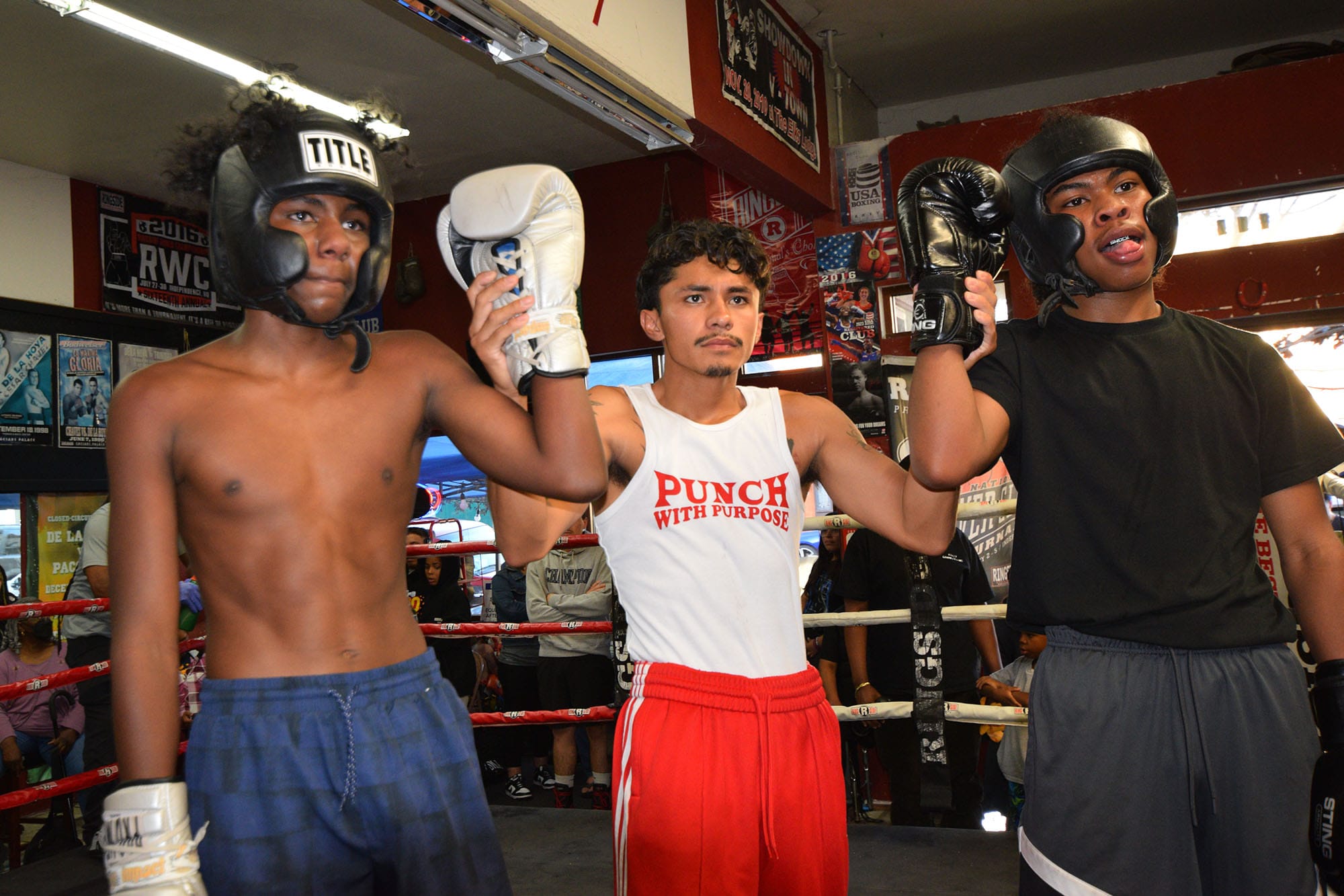 El entrenador de boxeo Luis Alberto Ramírez (centro) presenta a dos boxeadores en el combate de boxeo PAL del viernes. 