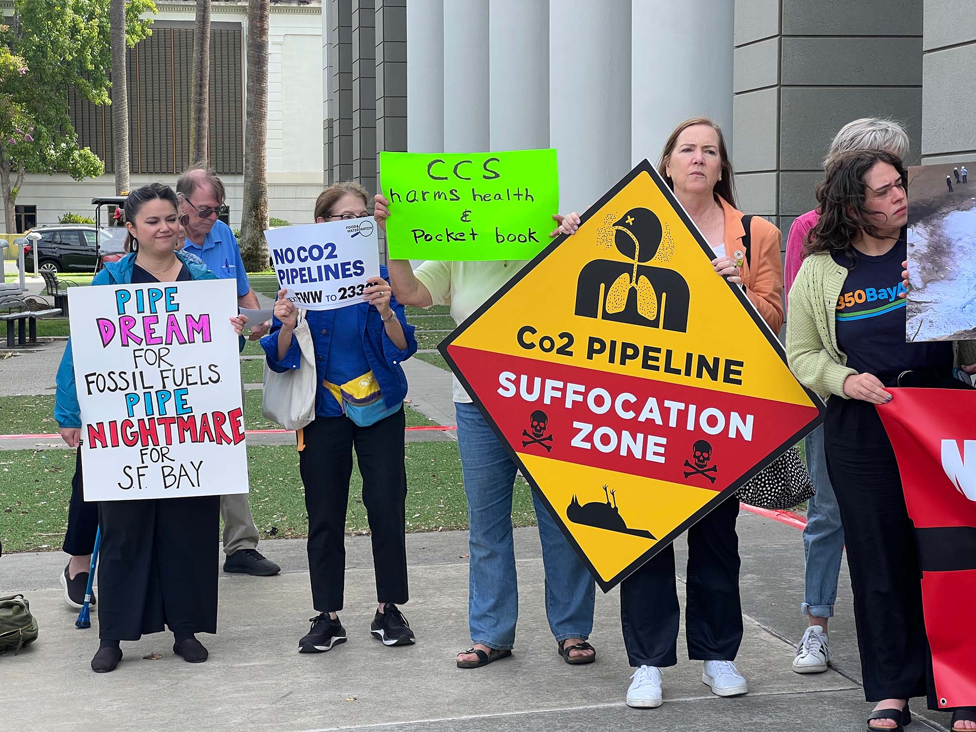 Protesters holding signs opposing the proposed carbon dioxide&nbsp; pipeline.