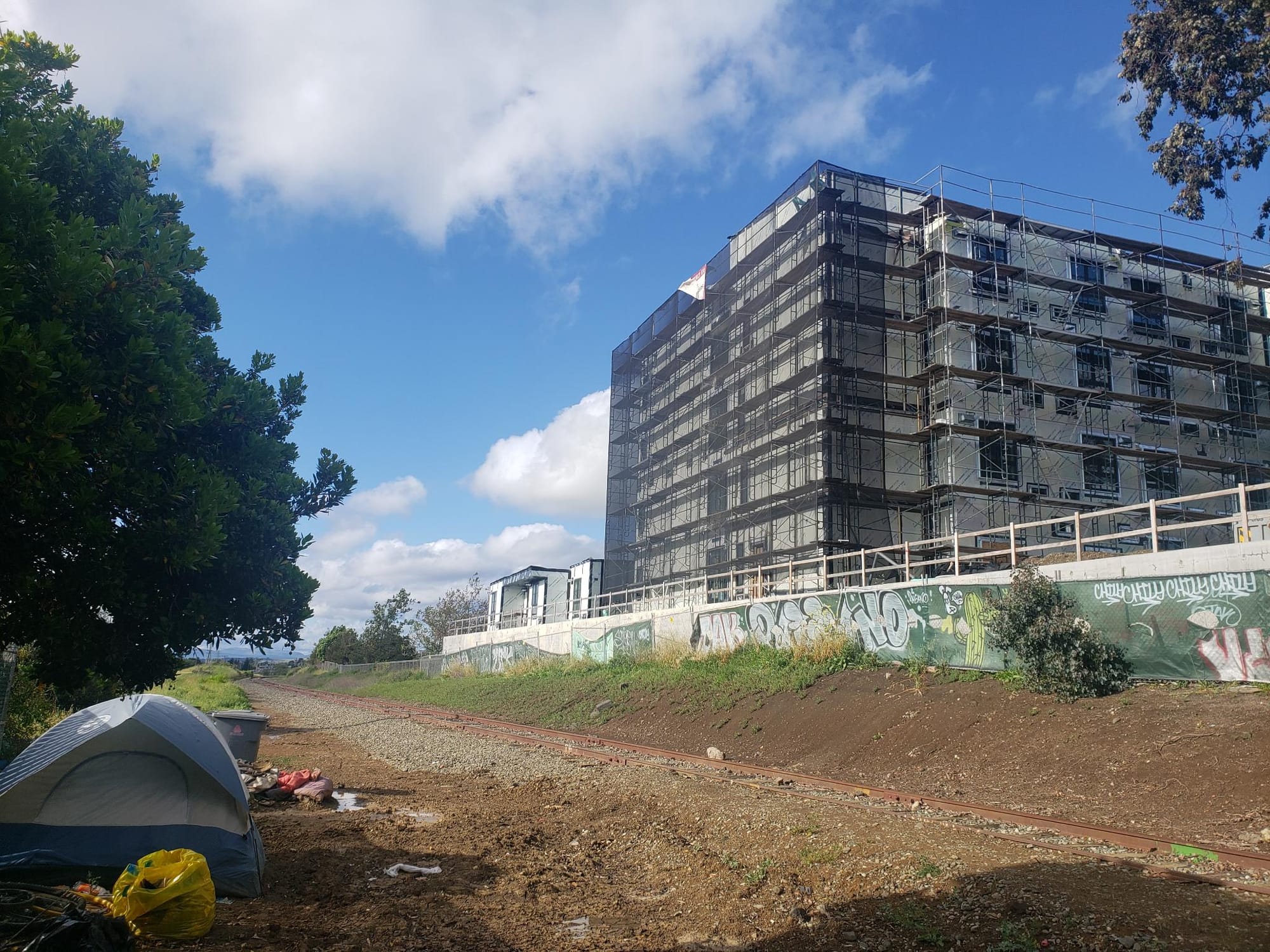 A tent outside an under construction building.