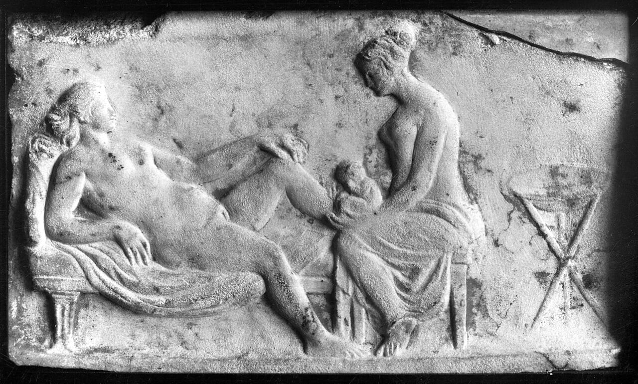 An ancient Roman relief carving of a midwife attending a woman giving birth. 