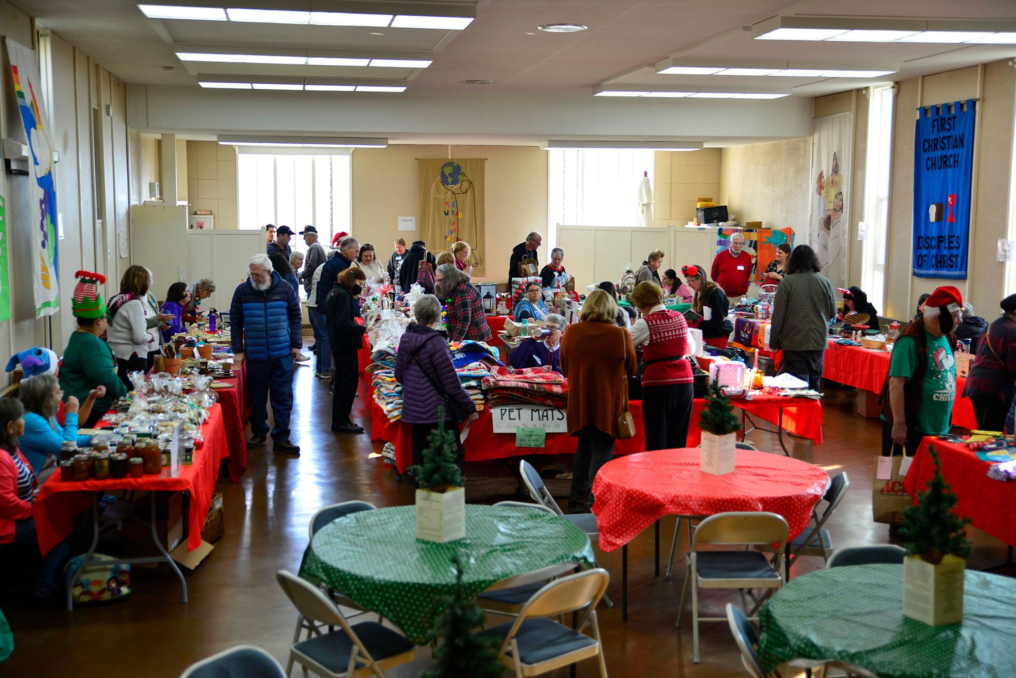 Volunteers sit at the tables at the Global Holiday Faire.