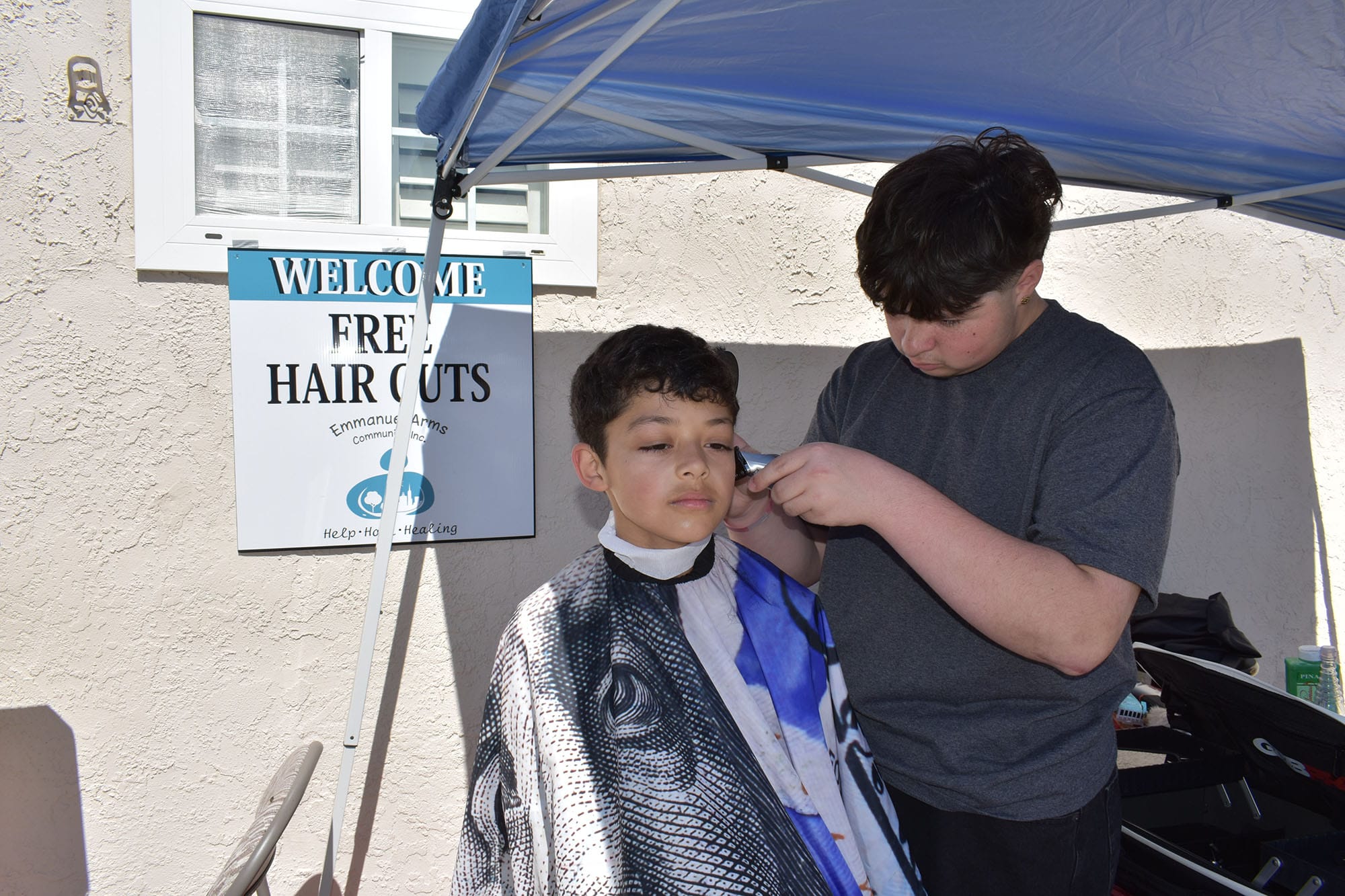 Izaiah Garman cuts hair at Thursday's event at Emmanuel Temple.