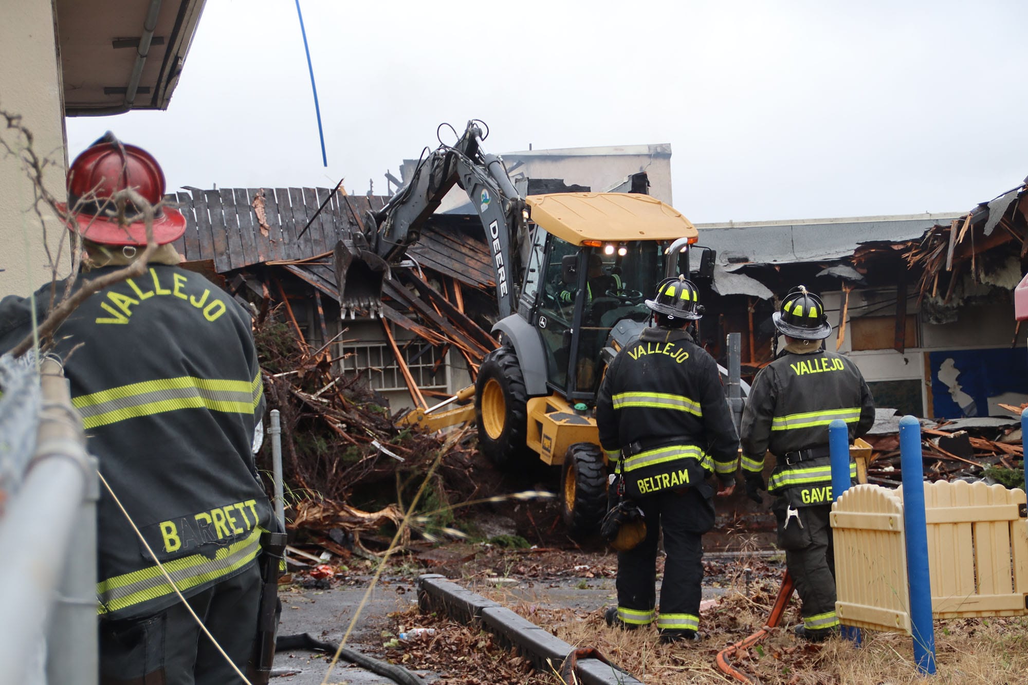Firefighters knock down portions of the shuttered Grant School after a fire Saturday morning.
