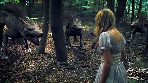 In a forest, three exceedingly unconvincing CGI dogs snarl at a young woman with blonde hair in a blue dress, which doesn't look like Snow White but an awful lot like Alice of Wonderland.