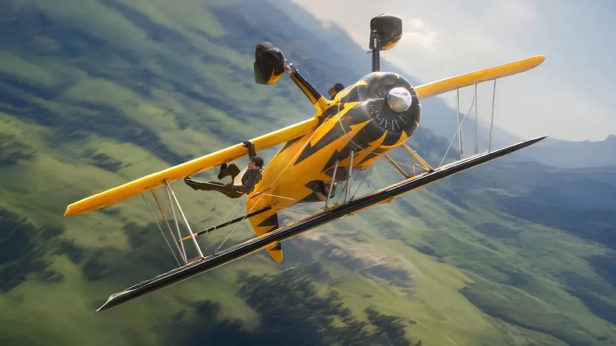Tom Cruise, climbing up the lower wing of an upside-down yellow biplane over the South African countryside