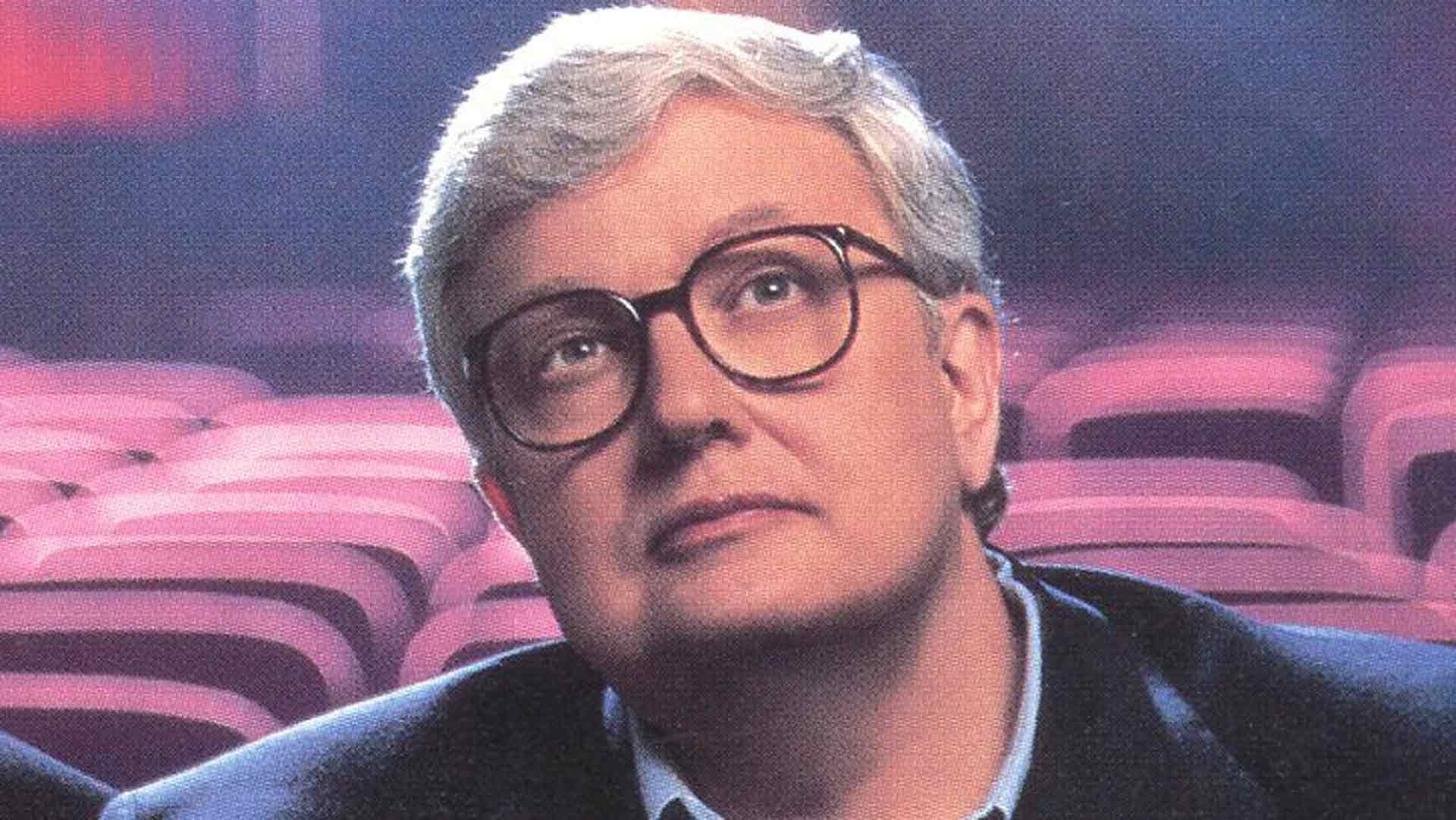 Roger Ebert, seated in a theater, looking up at the screen.