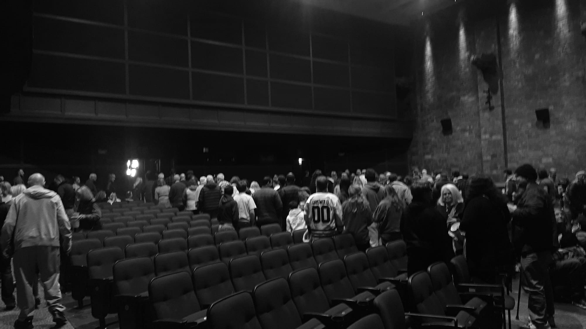 A nearly full theater audience emptying out.