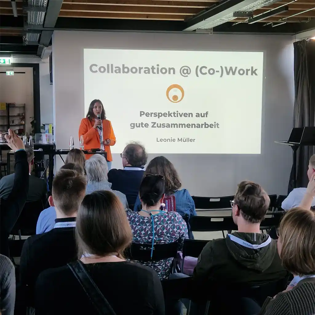 Leonie Müller giving a speech in front of a presentation screen.