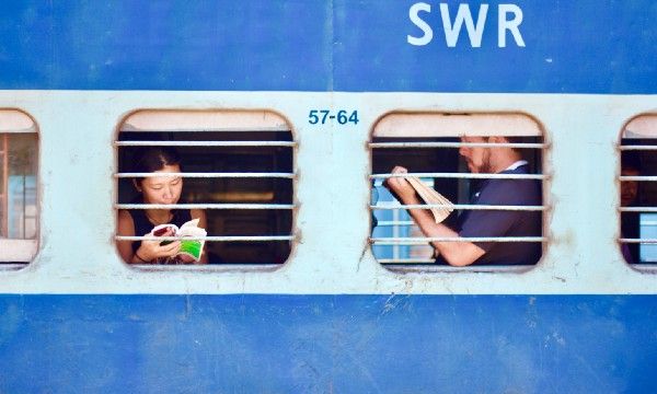 people on train behind windows, reading magazines