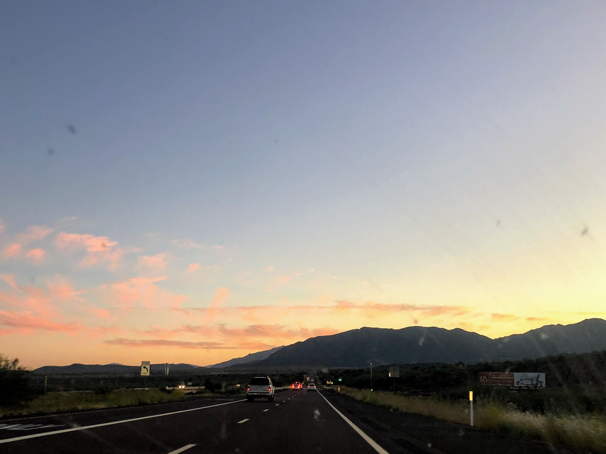Driving on road to the Dirt Road Sunset spot with the sunset in view over the mountains in Tonto National Forest.