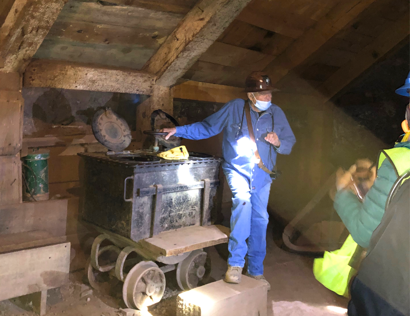 A man in a blue jumpsuit giving a tour of the Queen Mine in Bisbee, 1,500 feet below ground.