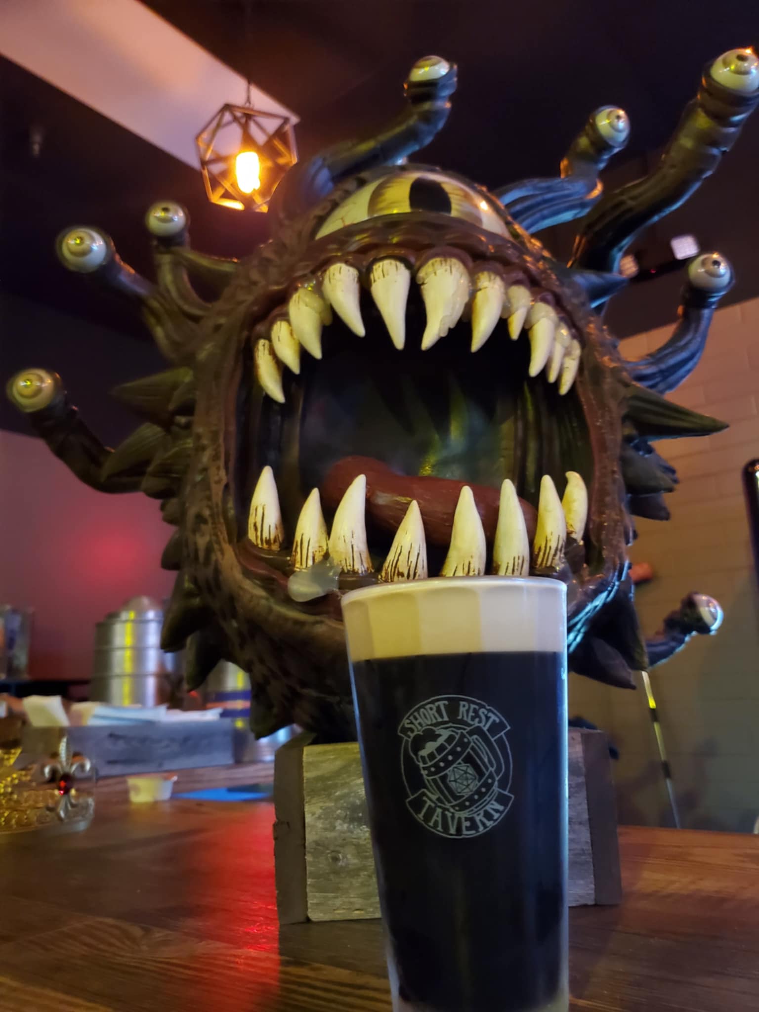 Fantasy creature statue with sharp teeth displayed inside Short Rest Tavern, the fantasy themed speakeasy in Tucson featuring mead, board games, and role-playing decor.