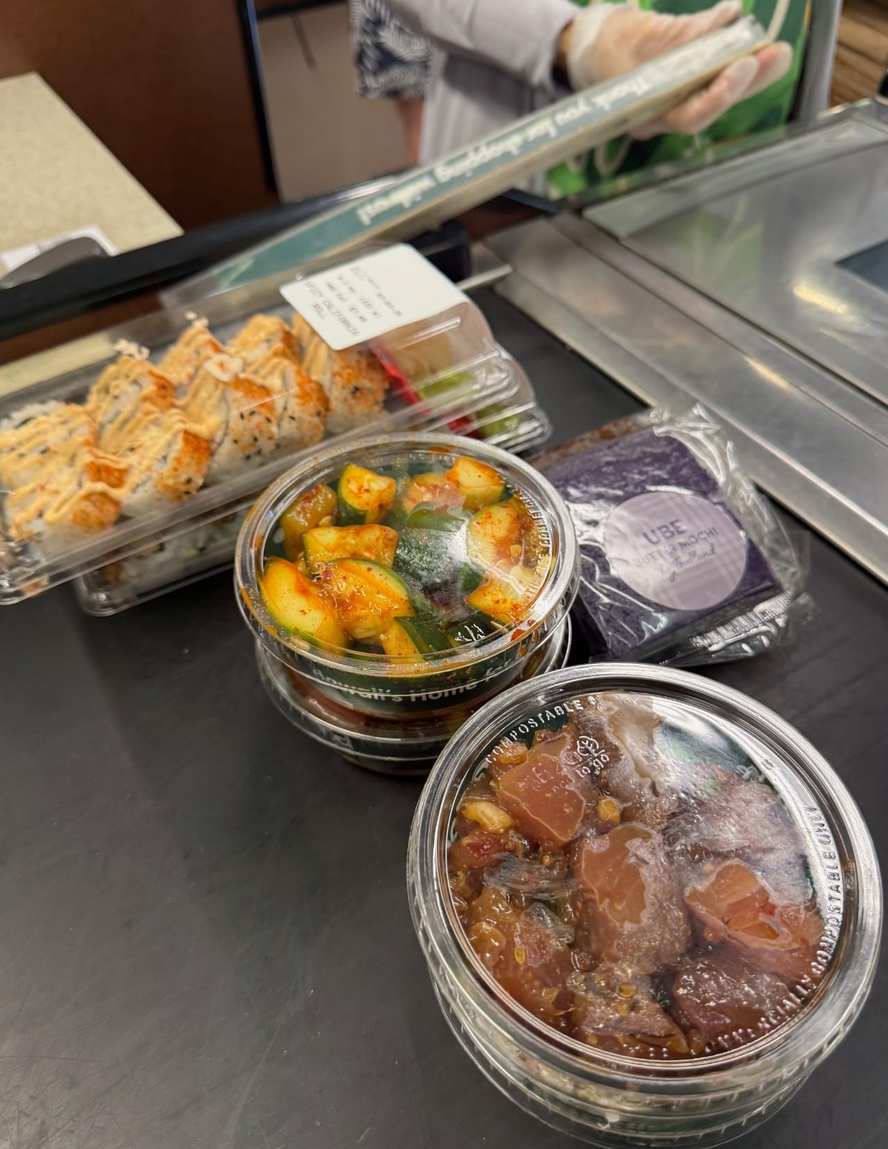 Fresh Poke, Ube mochi pastry, and sushi rolls from Foodland in Maui, Hawaii