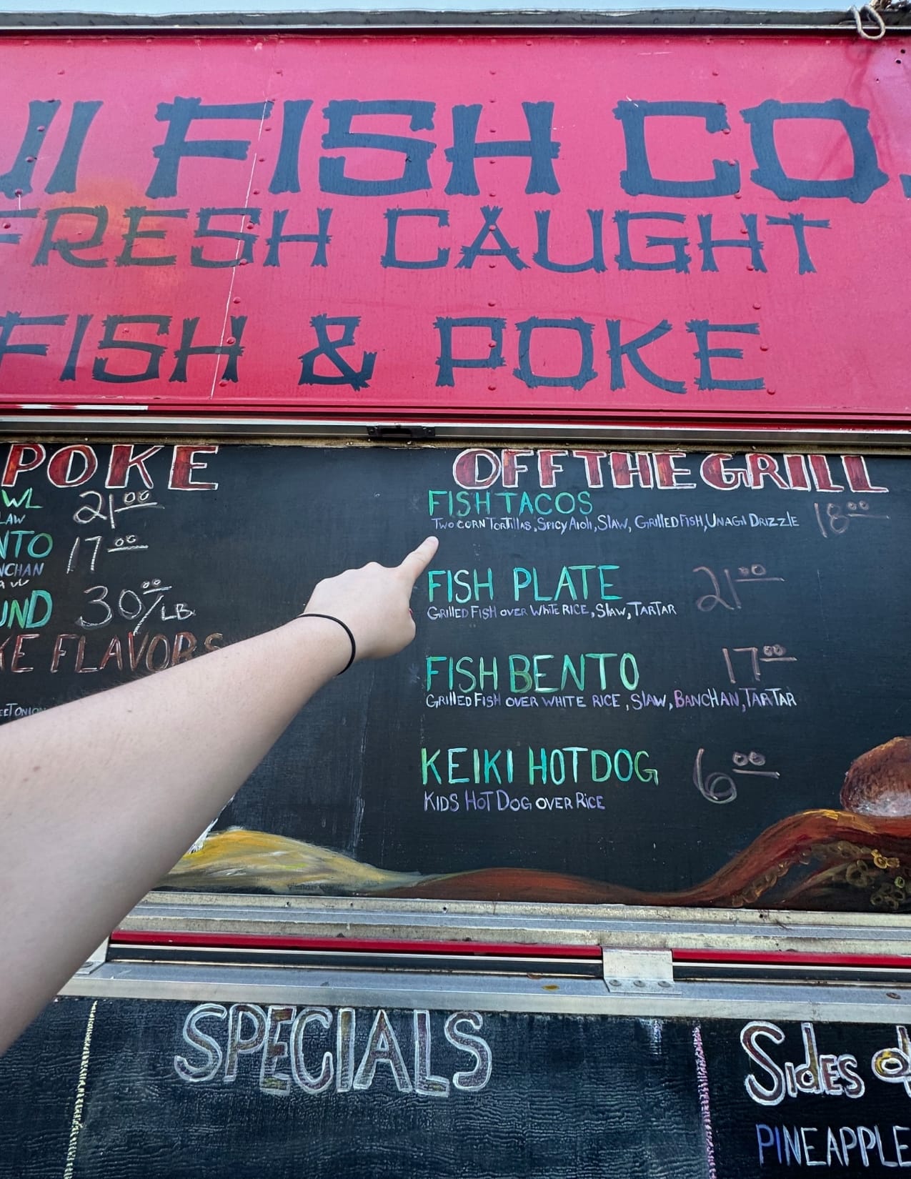 woman's arm pointing at fish taco menu item at South Maui Fish Co. in Maui, Hawaii