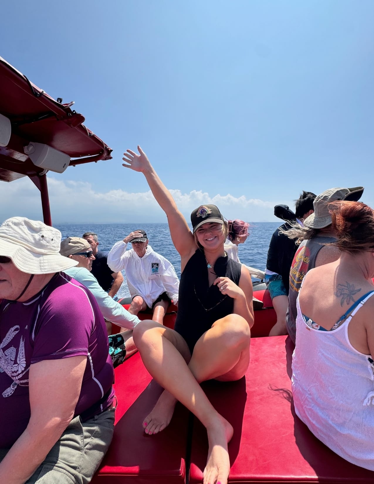 Woman seated with hand up on raft for a humpback whale watching tour in Maui, Hawaii