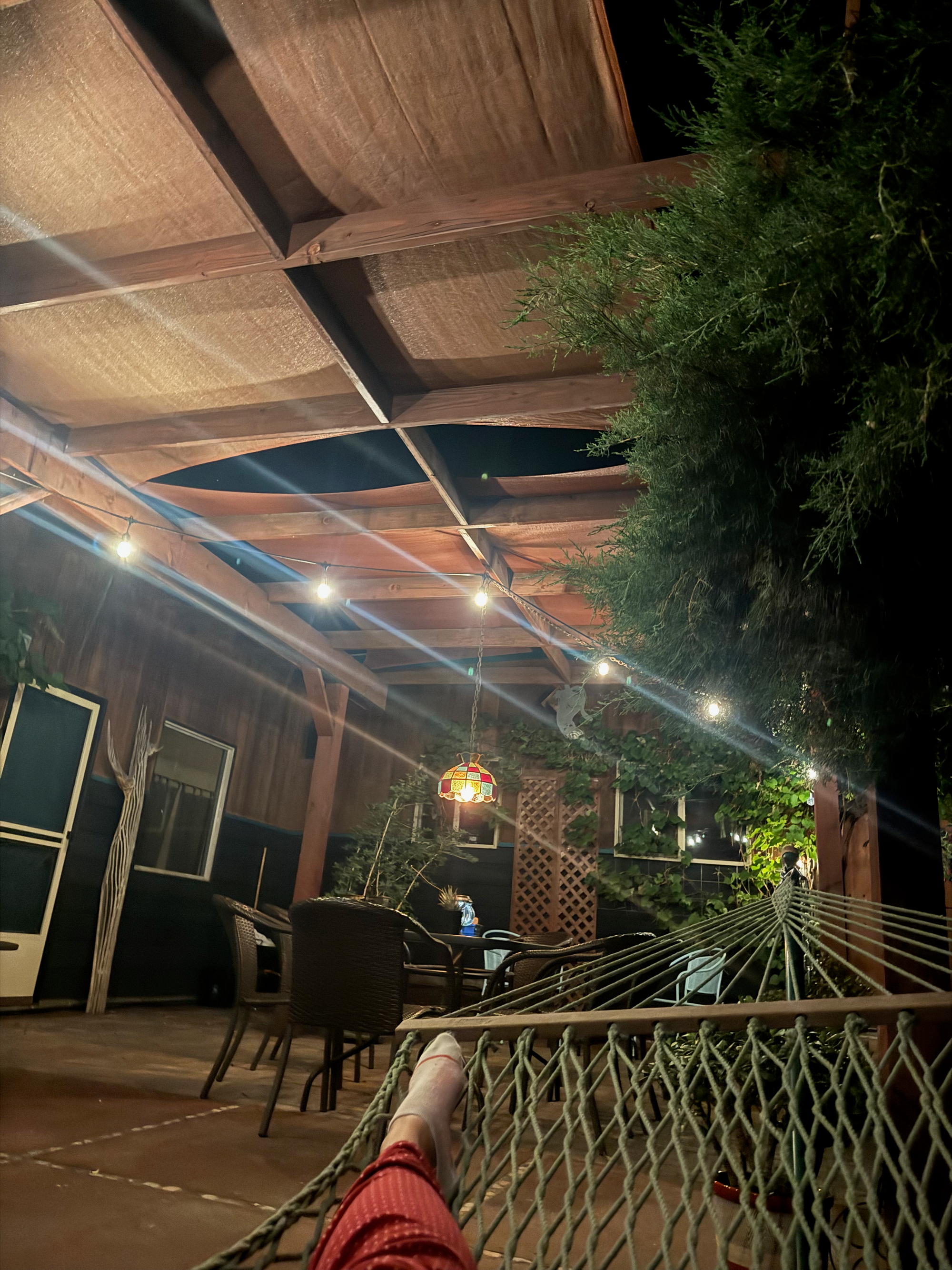 Woman's foot shown while laying on a hammock looking at the back patio area at the Westwater Room Airbnb in Moab, Utah