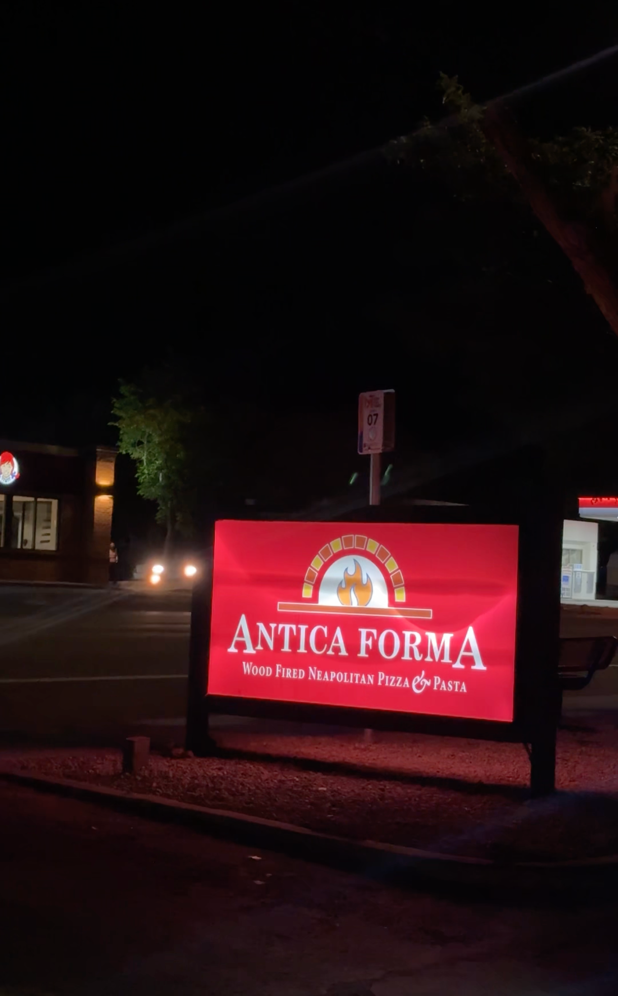 Red sign reading "Antica Forma Wood Fired Neapolitan Pizza & Pasta" in Moab, Utah