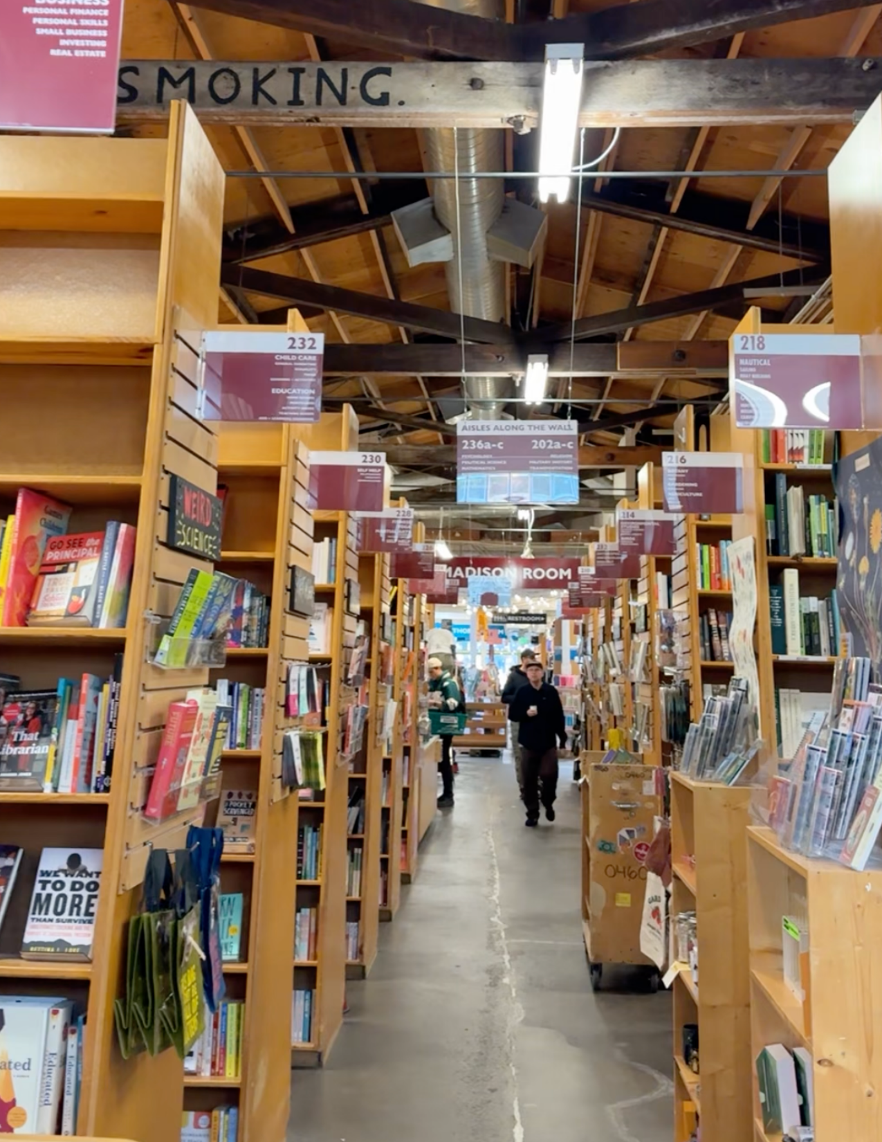 Hallway of book store of Powell's books with people walking on Hawthorne in Portland Oregon