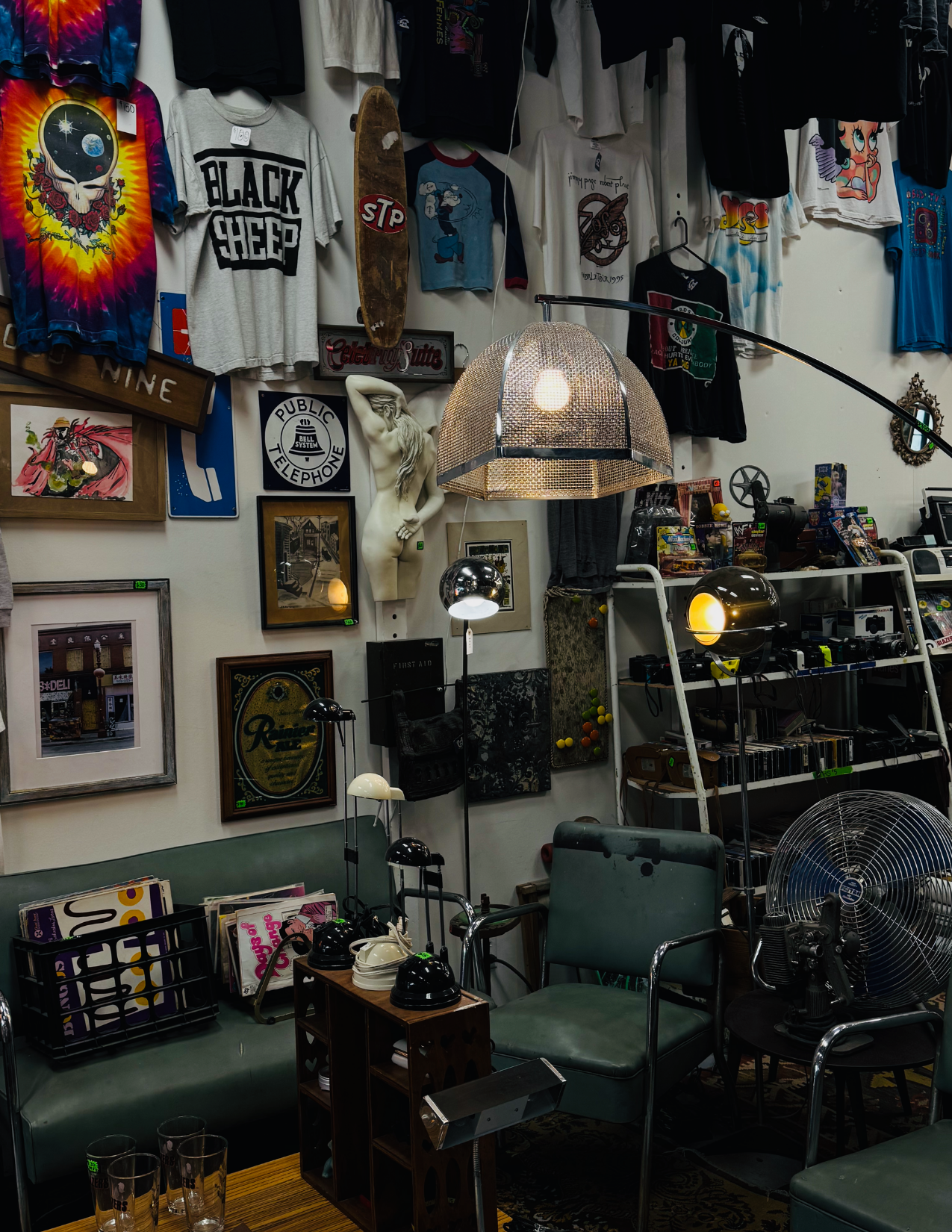 an assortment of t shits, pictures, chairs, a couch and a lamp at Telephone Vintage in Portland, Oregon