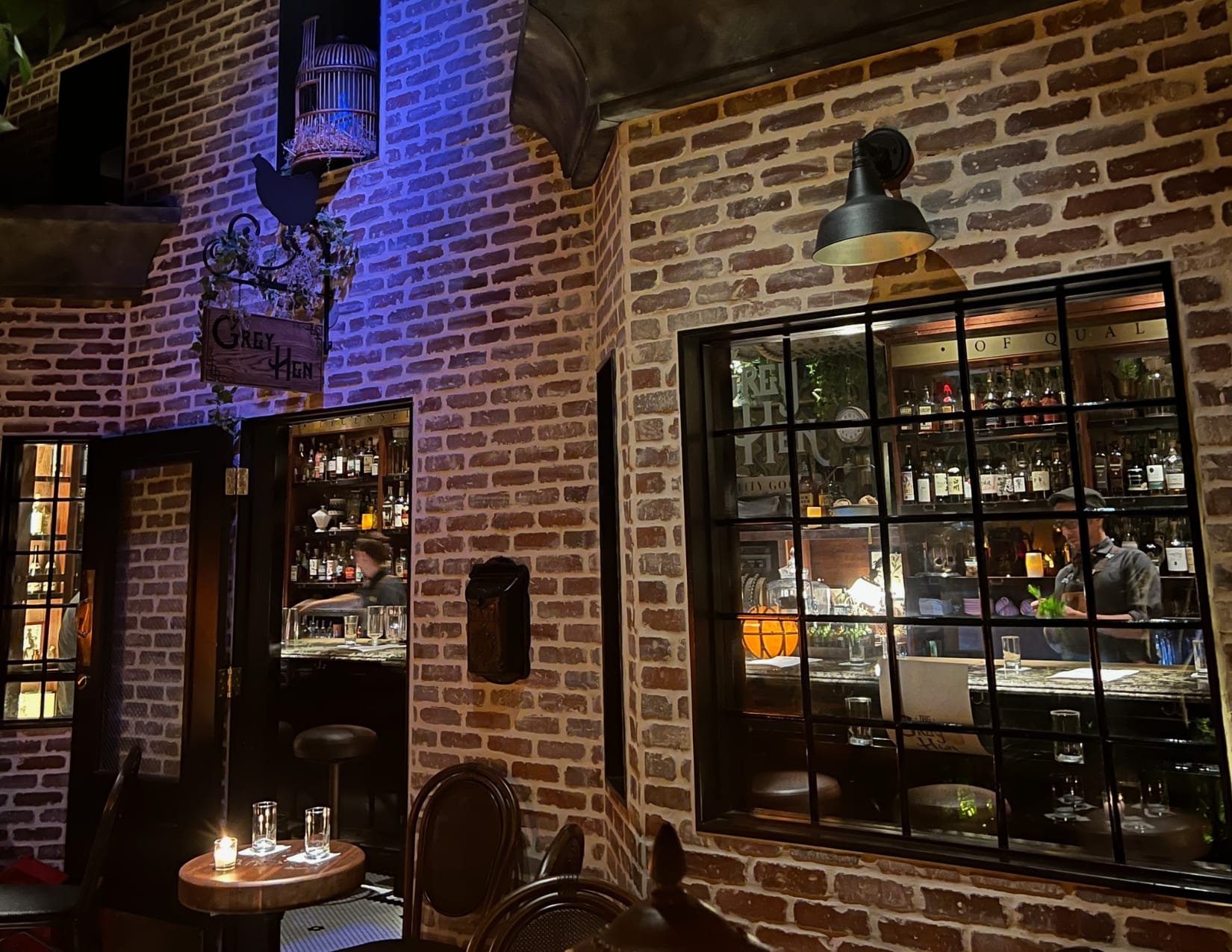 Brick building with moody lighting showing the speakeasy Grey Hen Rx at Century Grand in Phoenix Arizona