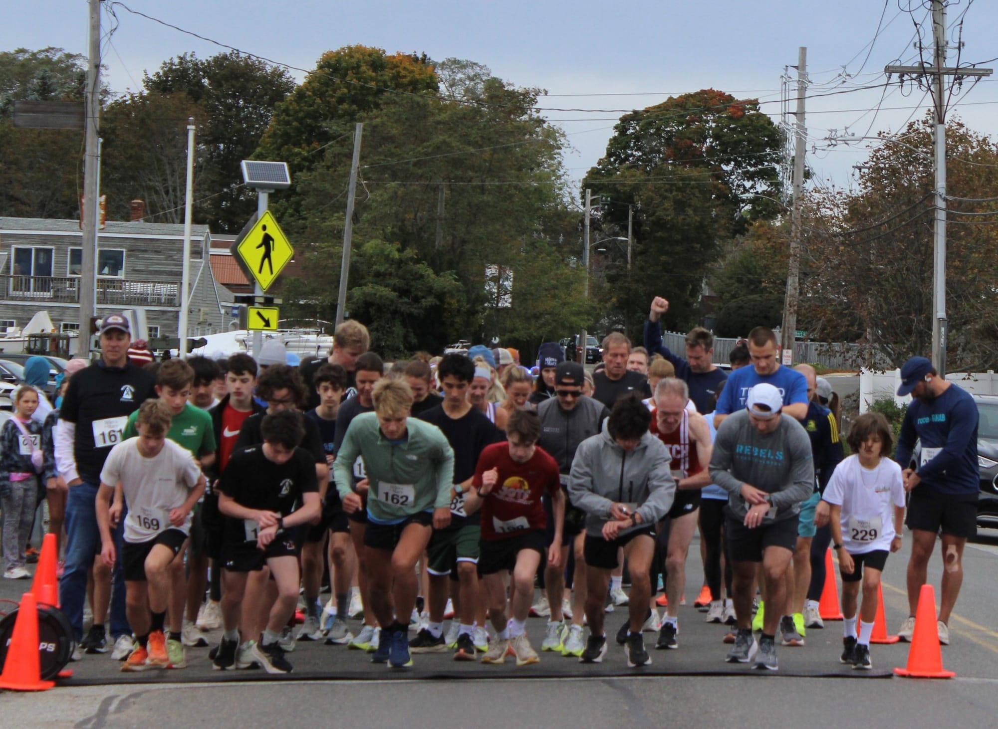 Runners checking their watches at the starting line of the Miles for Mary 5K