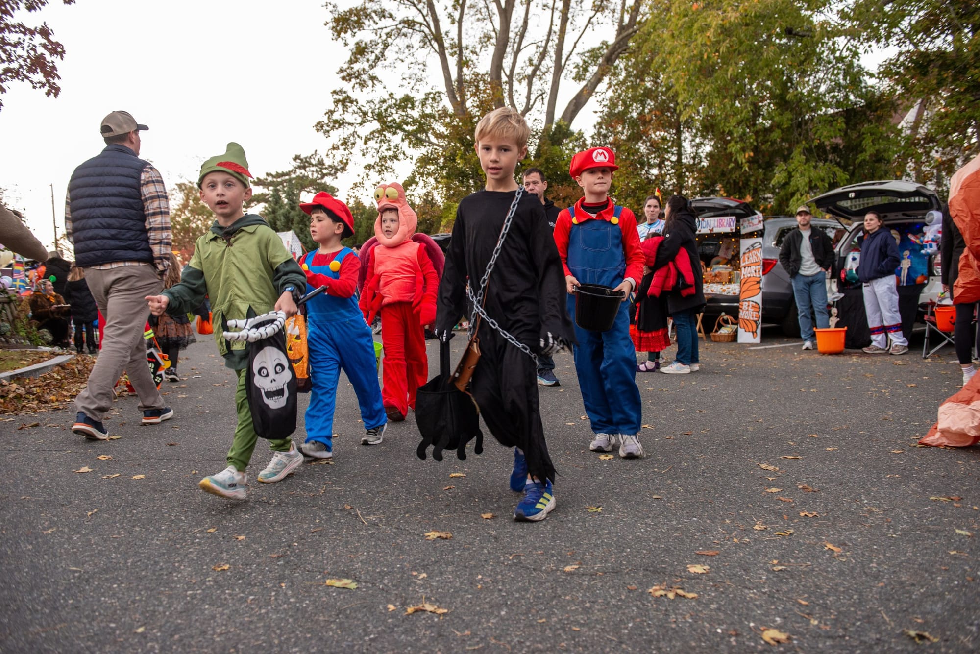Costumed children make their way between trunks with their candy buckets during Glover School’s Trunk or Treat.