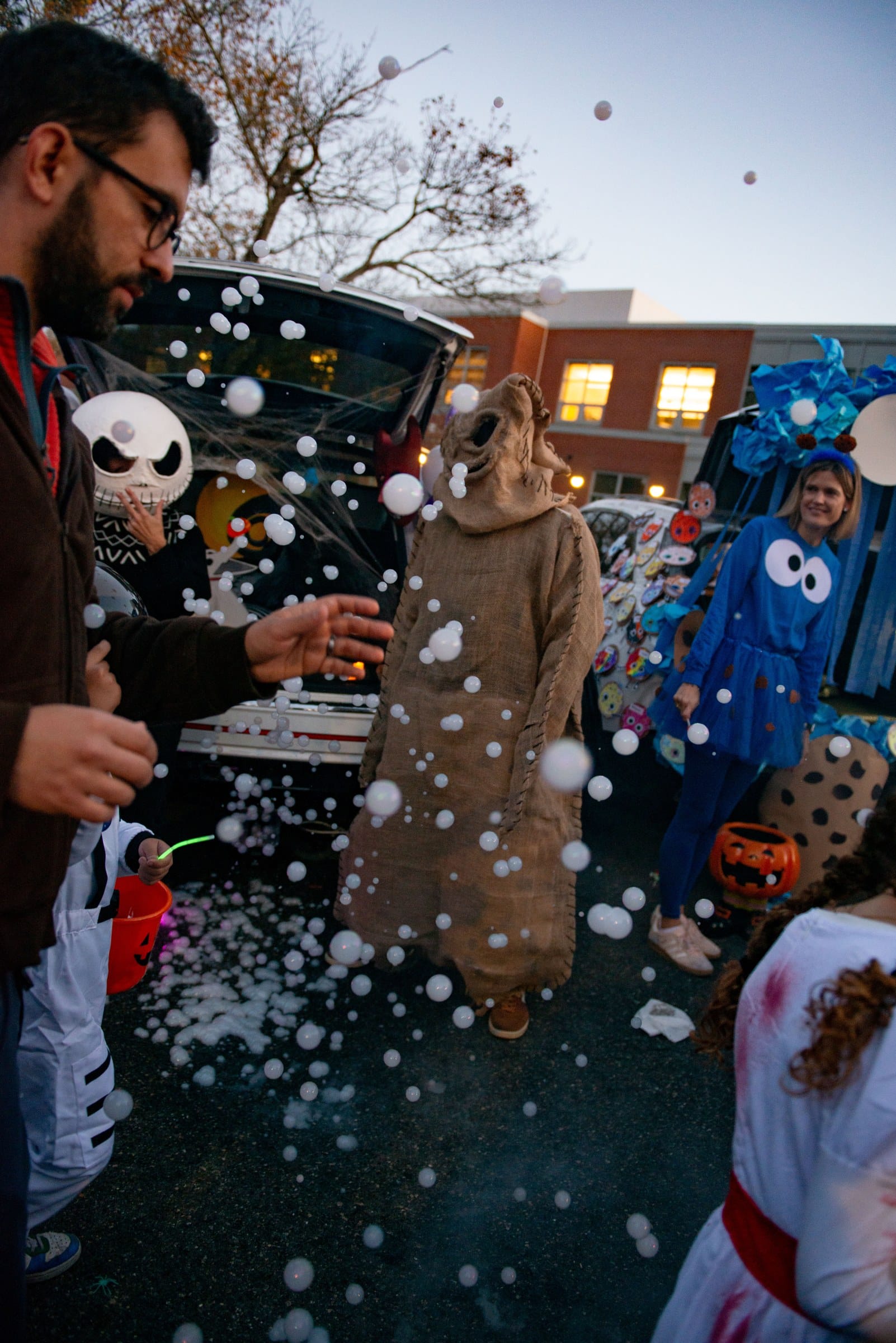 A person dressed as Oogie Boogie stands amid a flurry of white balls at a Nightmare Before Christmas-themed trunk during Glover School’s Trunk or Treat.