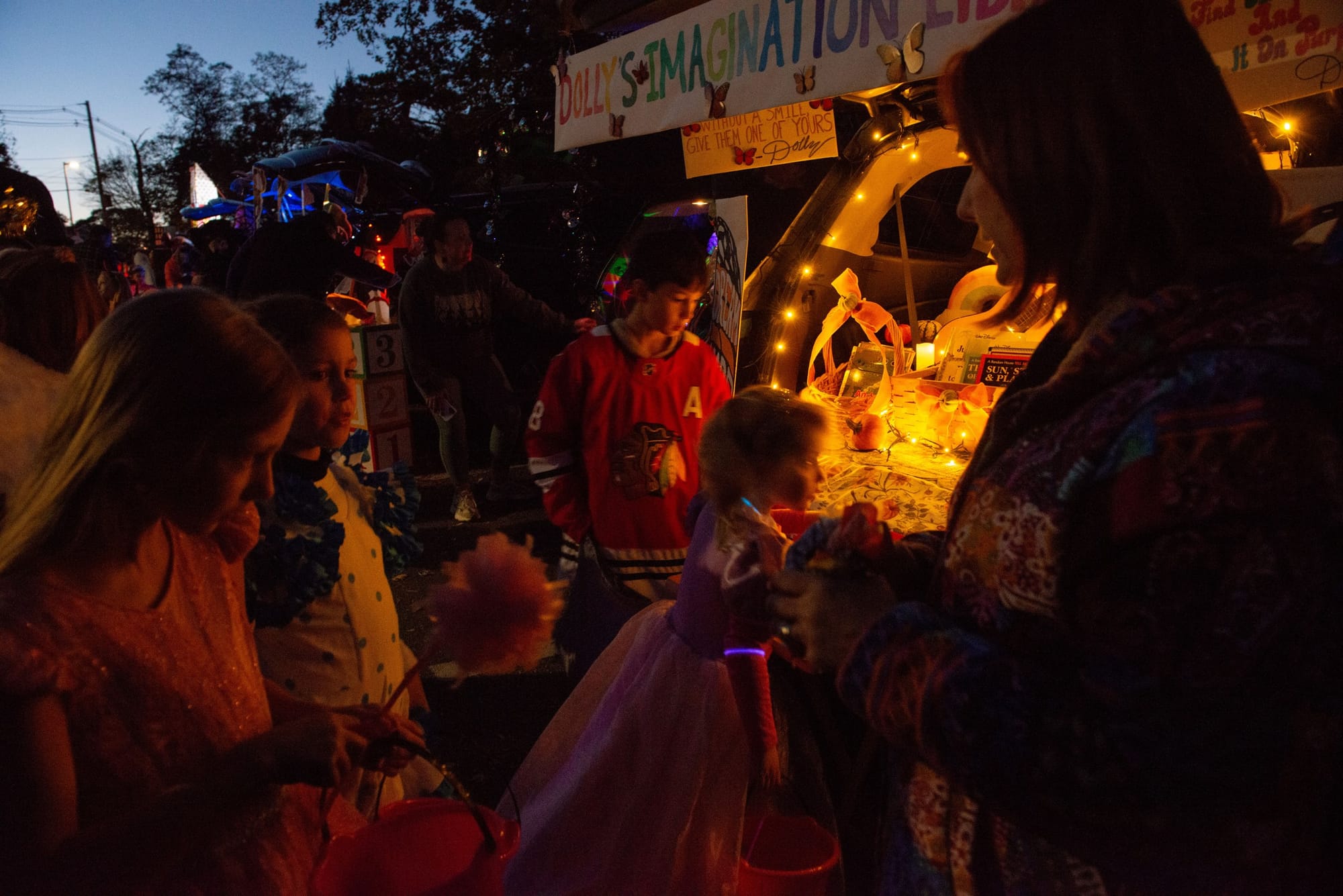 Children collect treats at the Dolly’s Imagination Library trunk as Jillian Peterson, right, hands out candy during Glover School’s Trunk or Treat.