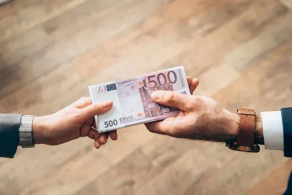 un bărbat înmână euro altui bărbat