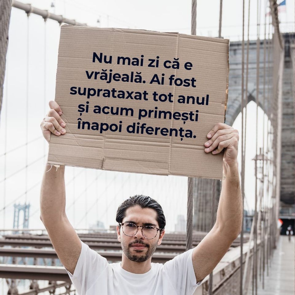 Bărbat care ține o placardă cu inscripție despre rambursarea banilor din taxe Germania
