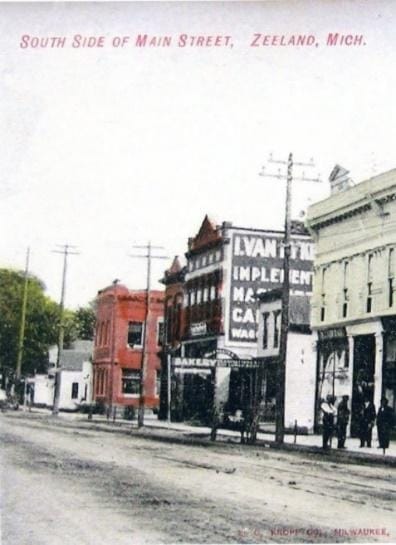 A street with buildings and people
Description automatically generated