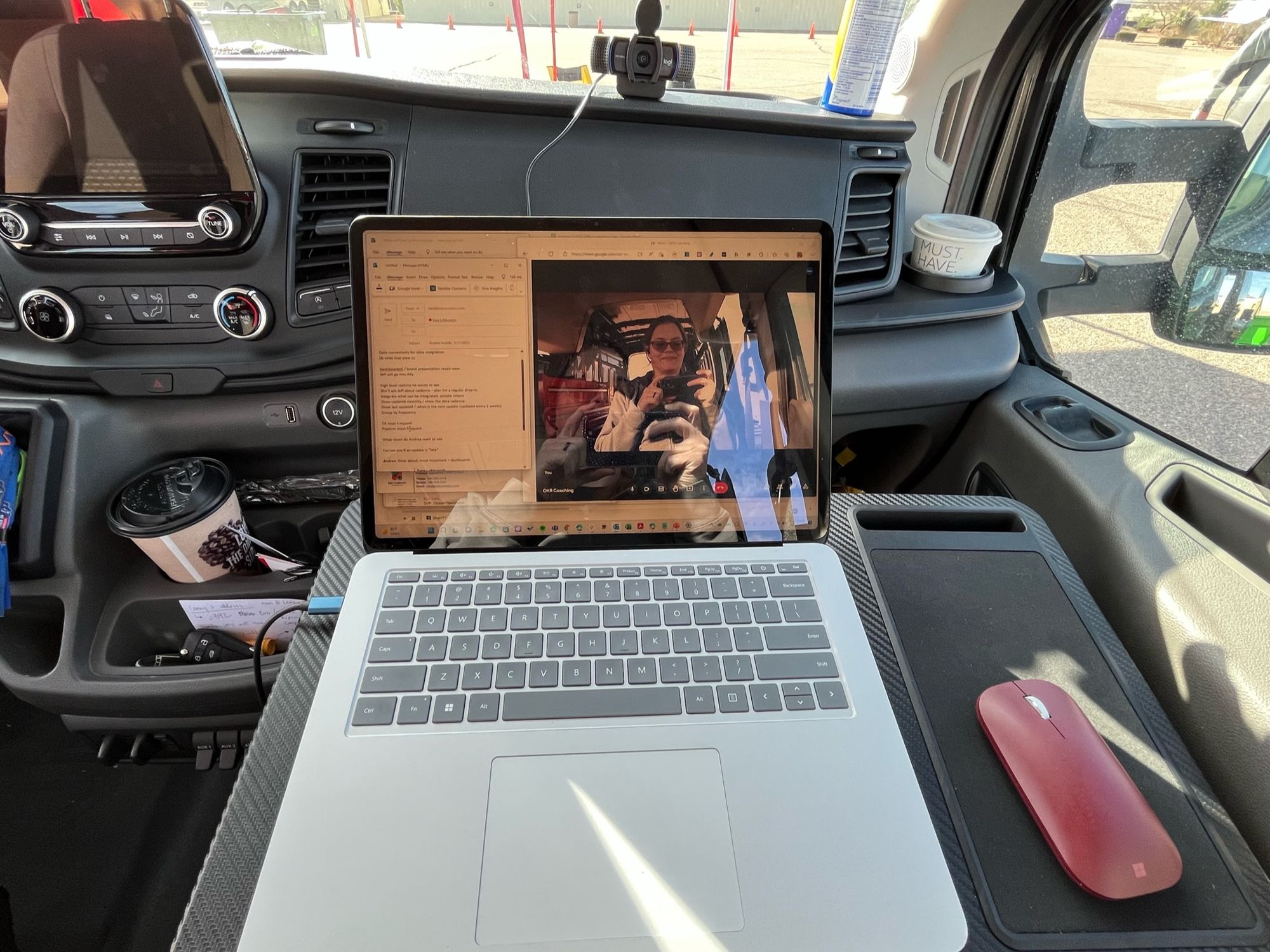 My view from the passenger seat of the van, with my lap desk, my Microsoft Surface Studio Laptop, and my mouse, and my webcam perched on the dashboard.