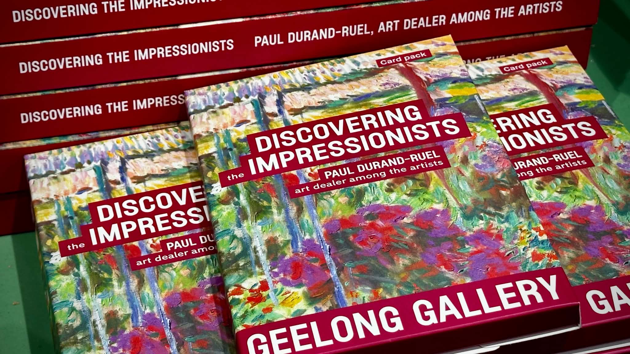 Stacks of Discovering the Impressionists books and card packs arranged on a green display table at Geelong Gallery.