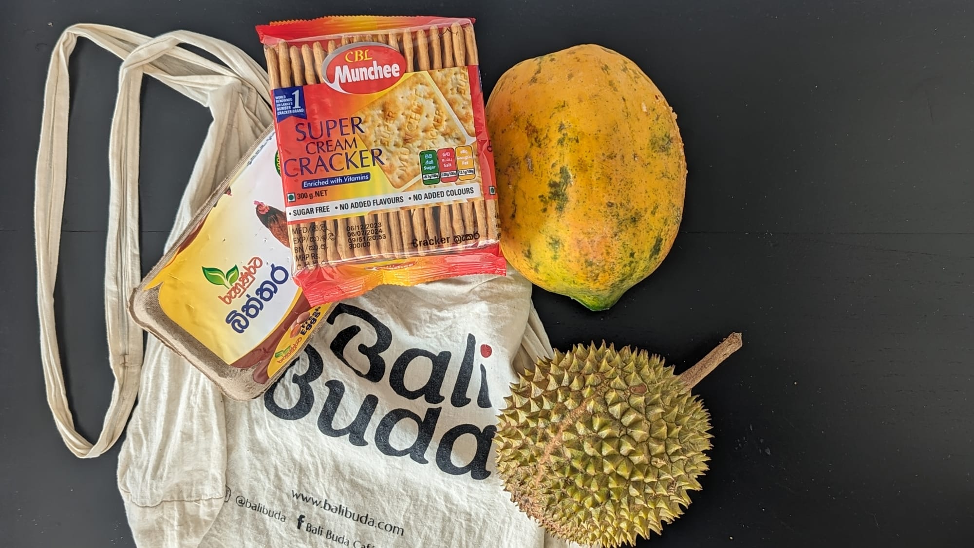 A durian, papaya, 10-pack of fresh eggs, and local cream crackers all for just a few dollars at local grocers