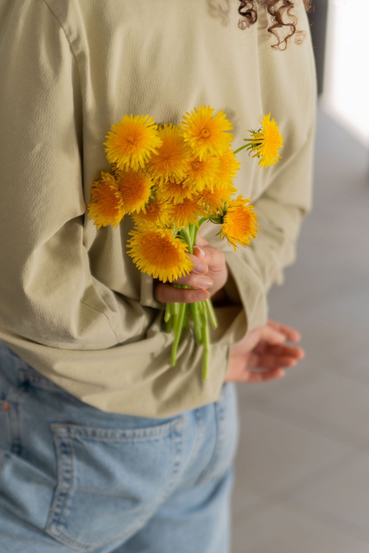 Hiding a bouquet of flowers behind the back.