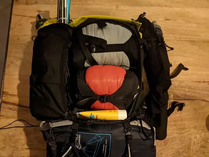 Sac de trail noir ouvert sur une table de bois