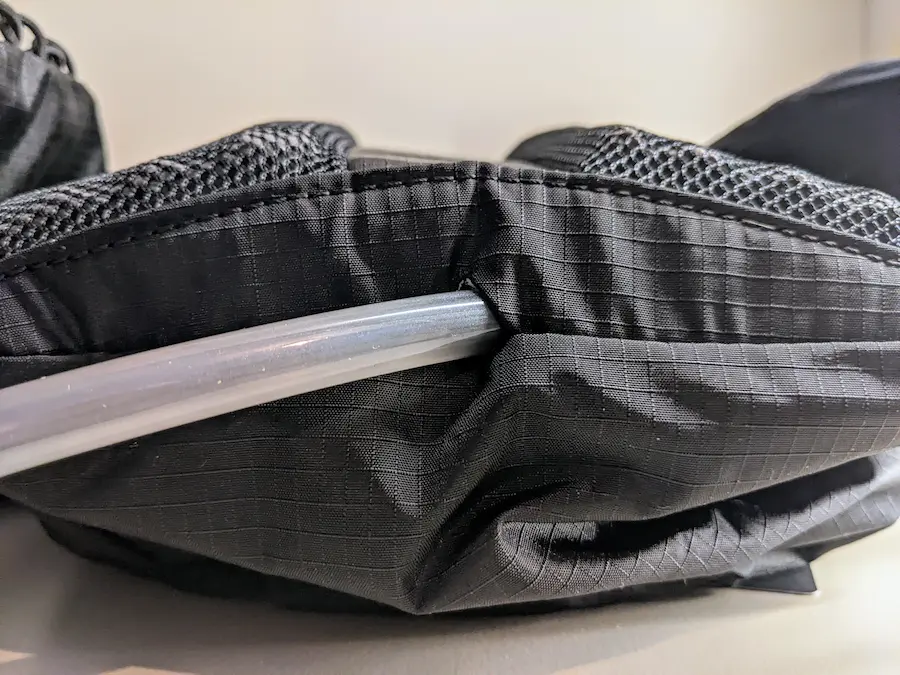 Sortie du tuyau de la poche d'eau sur un sac de trail noir