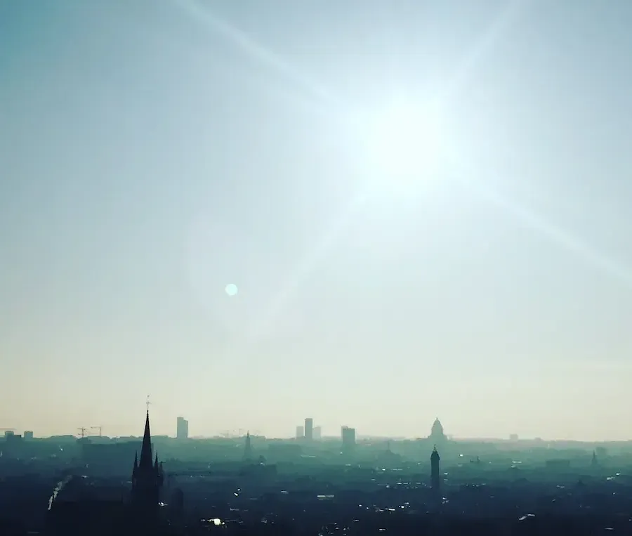 Soleil perçant le ciel bleu au-dessu de la ville