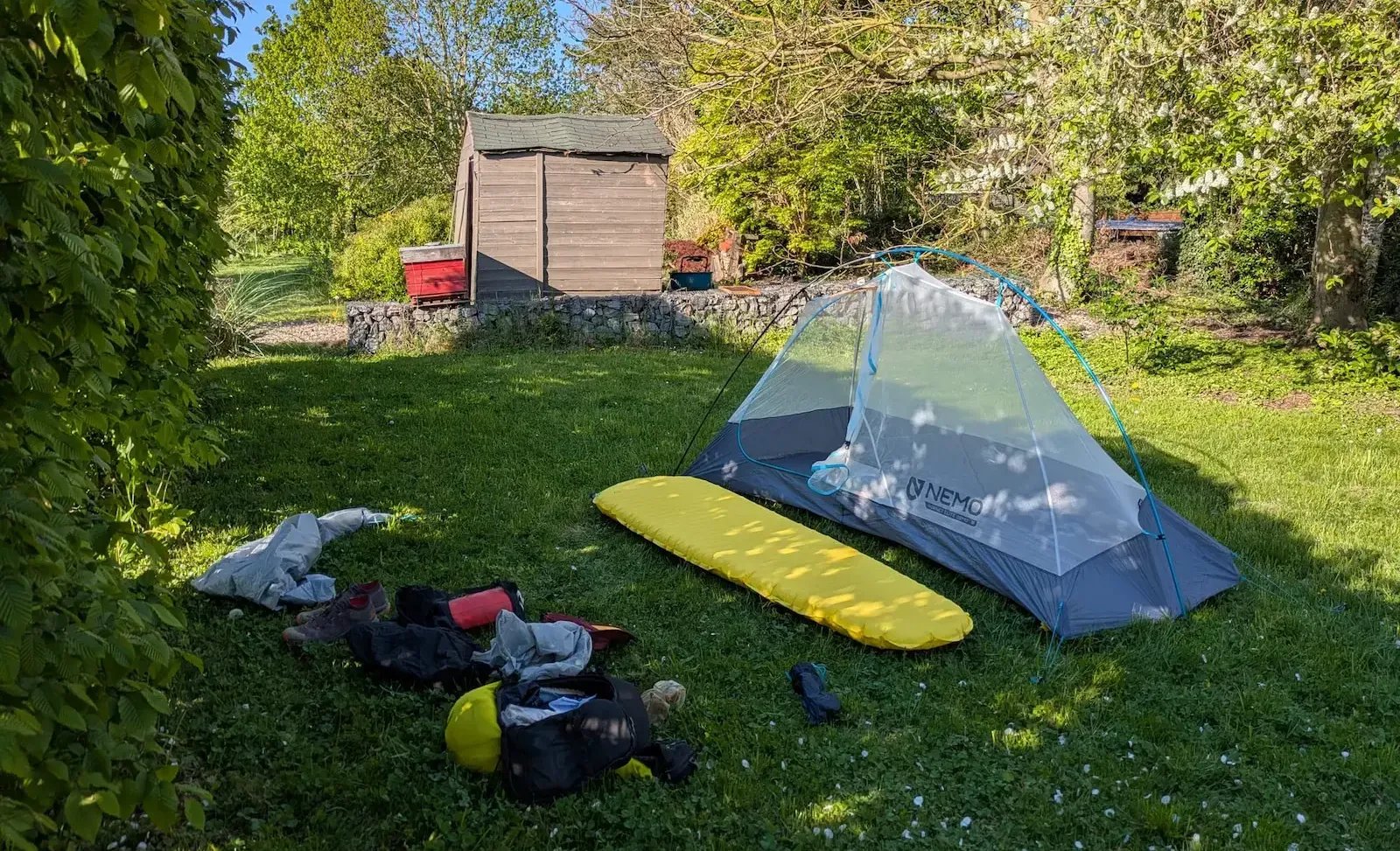 Matériel bivouac pour trail en itinérance posé sur du gazon 