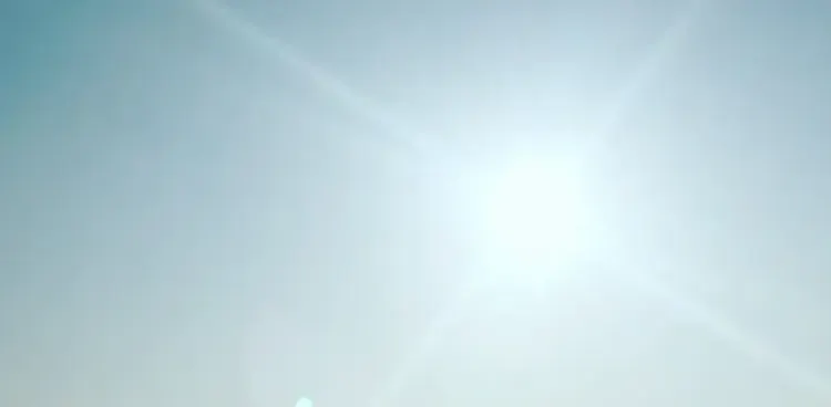 Soleil perçant le ciel bleu au-dessu de la ville